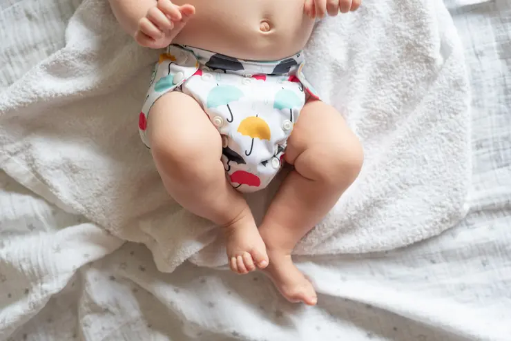 Ein Baby trägt eine mit Regenschirmen bedruckte Stoffwindel