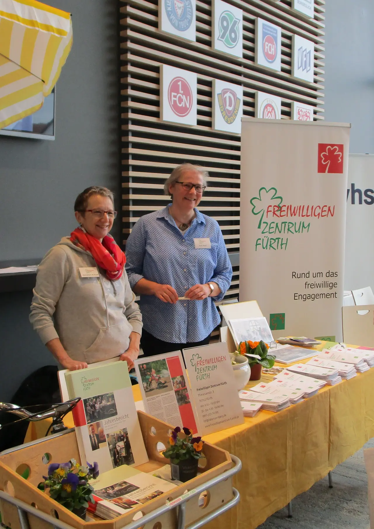 Zwei Frauen stehen lachend an einem Infostand des Freiwilligen-Zentrum Fürth