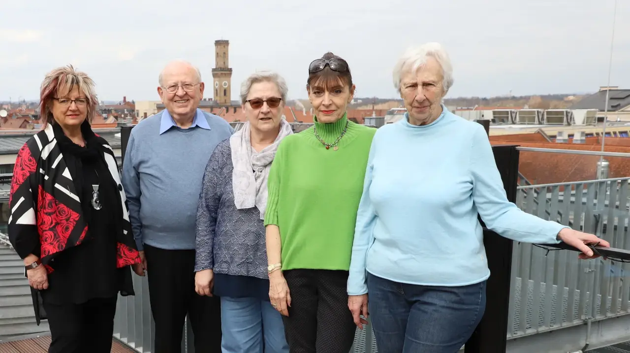 Die Mitglieder des Seniorenrats vor der Stadtkulisse mit Rathausturm im Hintergrund