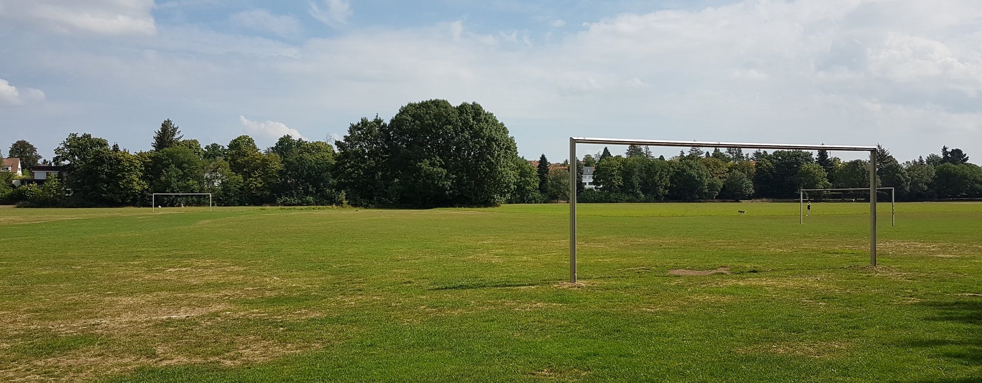 Bolzplatz mit weitläufiger Wiese und Bolzplatztoren.