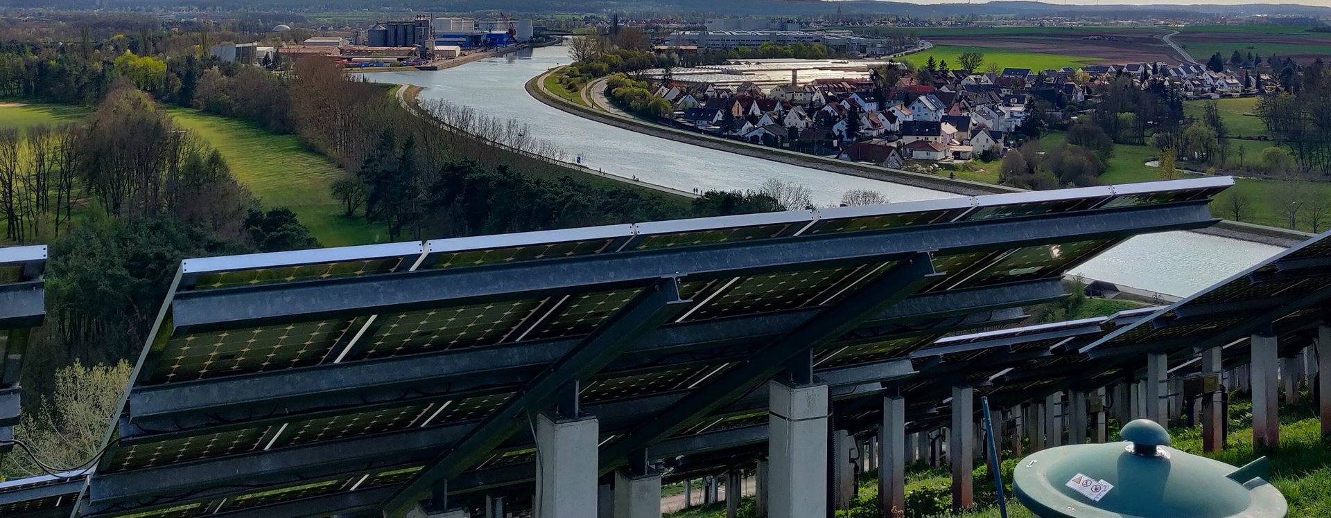 Blick von der Spitze des Solarbergs aus in Richtung Fürth mit PV-Anlagen im Vordergrund und dem Kanal im Hintergrund