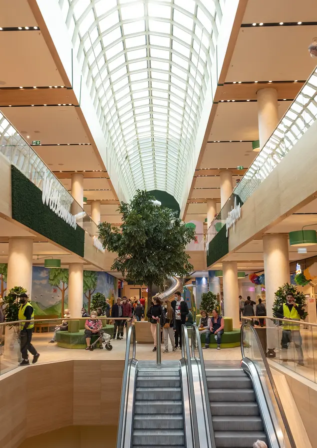 Innensicht des belebten Shopping-Centers Flair mit Rolltreppen und Glasdach.