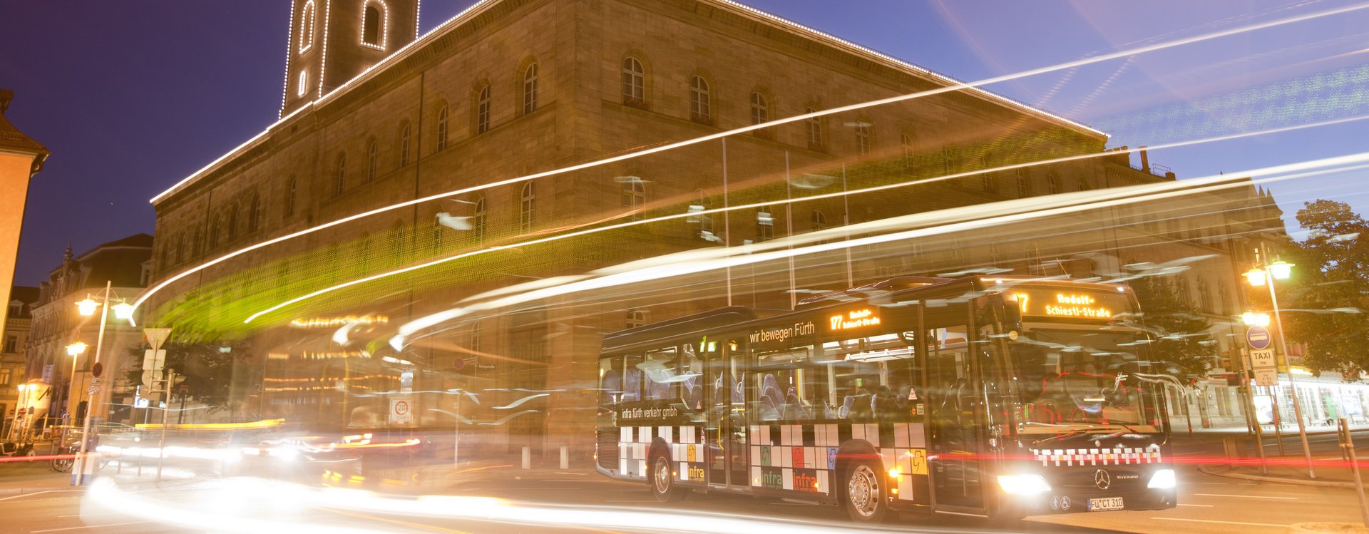 Nightliner Bus vor dem beleuchteten Rathaus