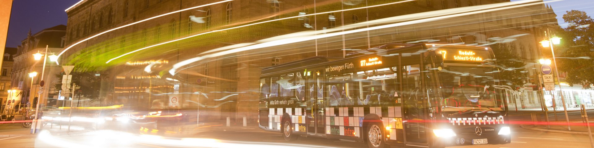 Nightliner Bus vor dem beleuchteten Rathaus