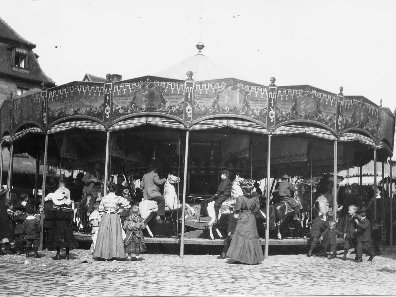 Historisches Schwarz-Weiß-Foto um das Jahr 1900 von einem Karussell und einer Menschengruppe auf der Michaelis-Kirchweih. 