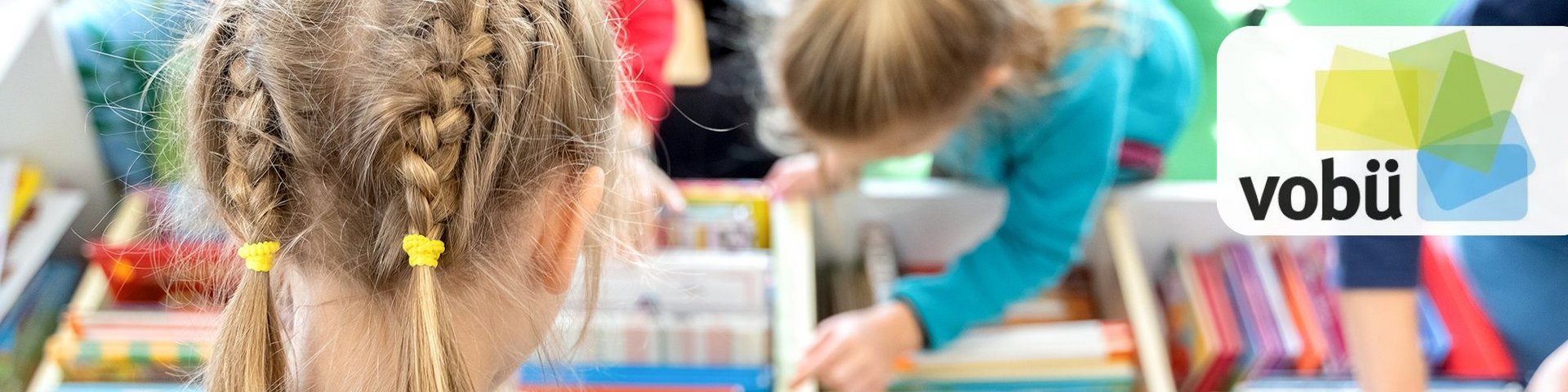 Mädchen suchen in einer Bücherkiste eifrig nach Lesestoff.