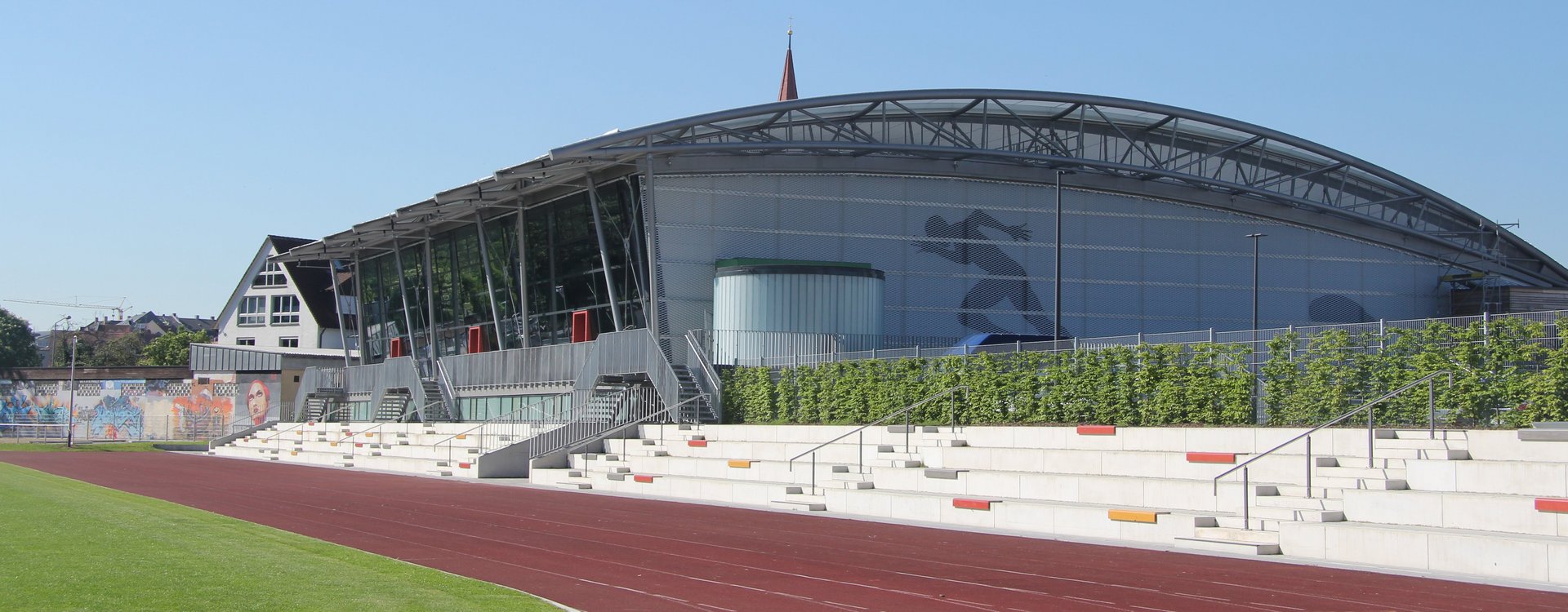 Außenansicht der Julius-Hirsch-Sporthalle inklusive Laufbahn