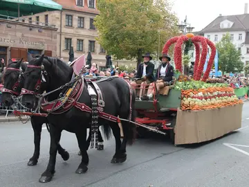 Die Kutsche mit der Erntekrone, die von zwei Pferden gezogen wird.