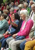 Lachende Seniorinnen und Senioren bei Veranstaltung auf der Freilichtbühne im Stadtpark