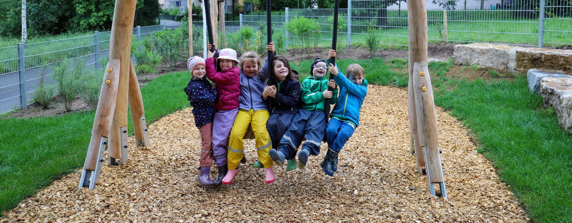 Sechs Kinder haben Spaß beim Schaukeln