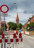 Die Baustelle mit Absperrungen und dem Kirchturm im Hintergrund.