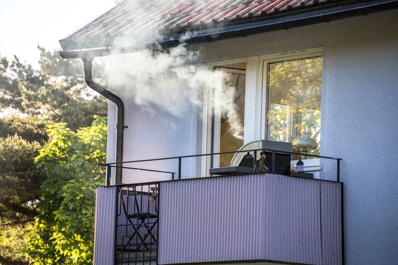 Grill raucht auf einem Balkon