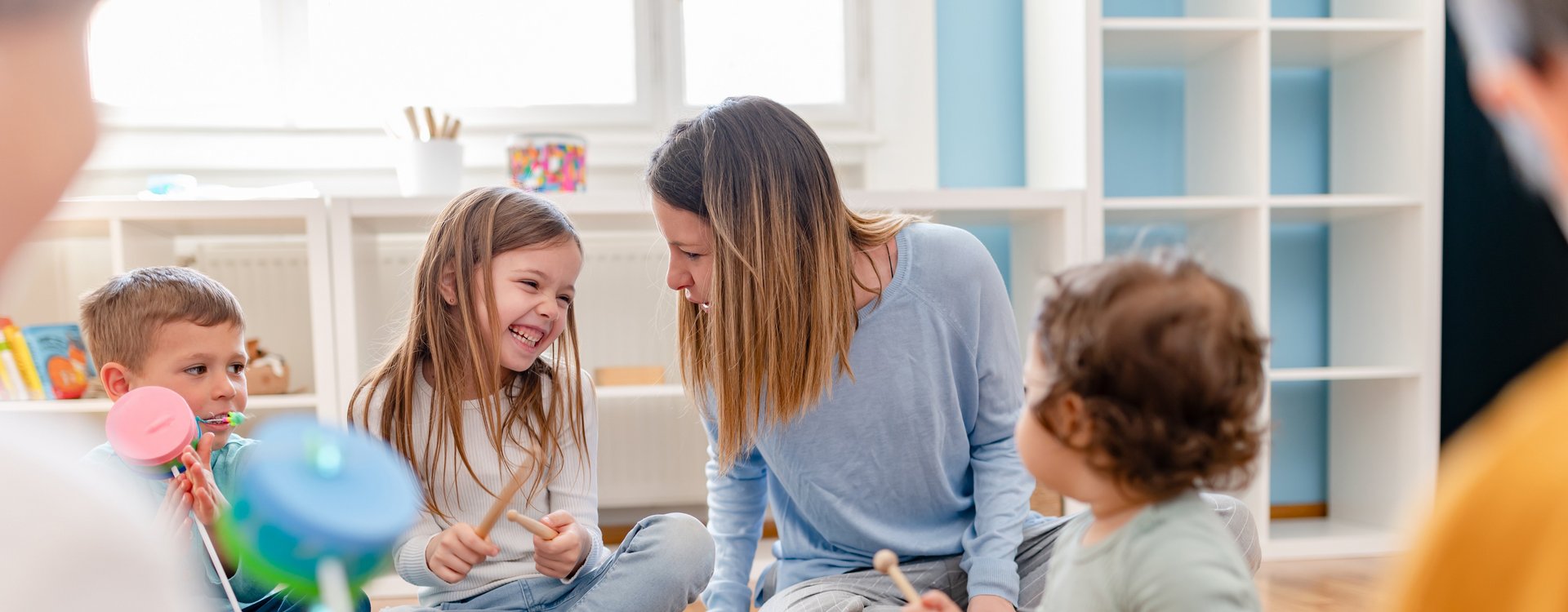 Erzieherin spielt mit Kindern Instrumente