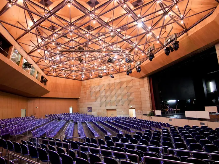 Blick in den bestuhlen großen Saal, rechts die eingerichtete Bühne. 