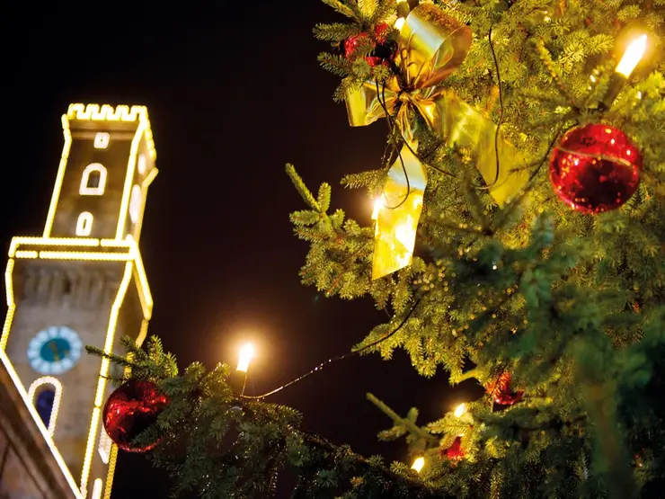 Weihnachtskugel an Baum in Nahaufnahme, Hintergrund zeigt das beleuchtete Rathaus; Klick zeigt Bild in größerer Darstellung