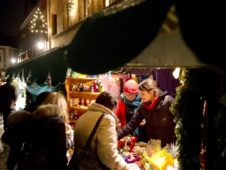 Personen schauen sich Spielzeug an einem Verkaufsstand auf der Altstadtweihnacht an.