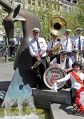 Eine Brass-Band posiert mit Instrumenten vor dem Paradisbrunnen auf der Fürther Freiheit.