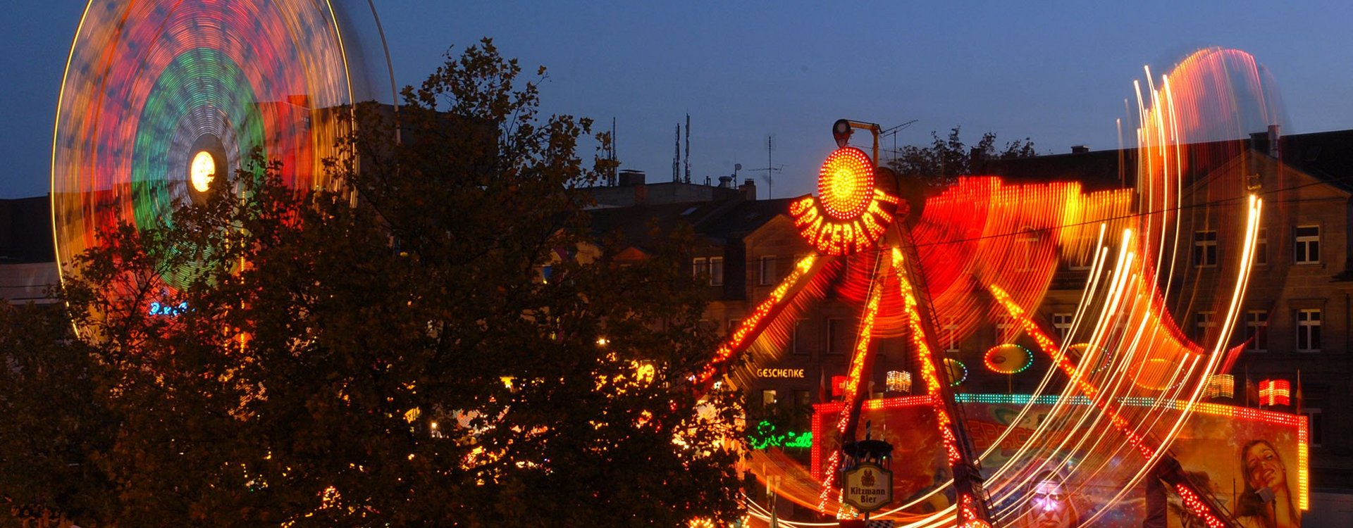 Michaelis-Kirchweih mit Riesenrad und Fahrgeschäft bei Dunkelheit