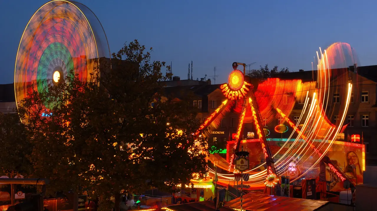 Michaelis-Kirchweih mit Riesenrad und Fahrgeschäft bei Dunkelheit