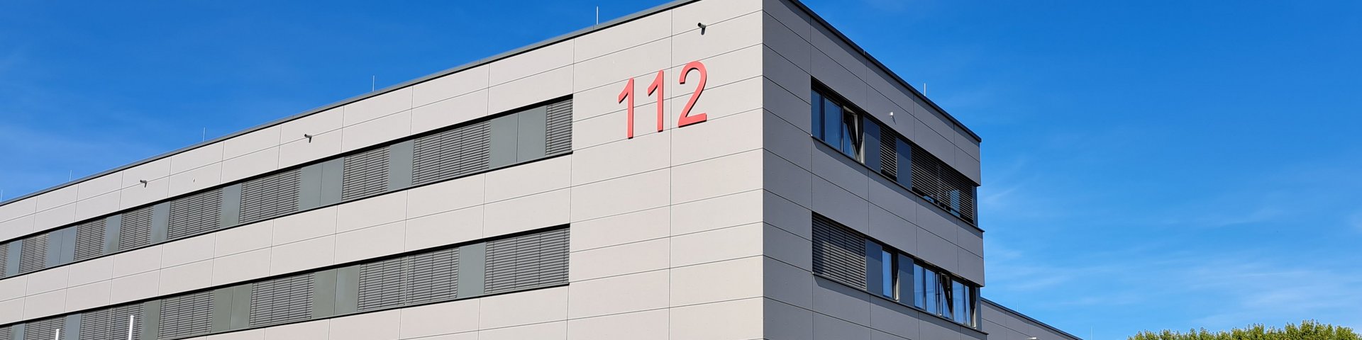 Ansicht der neuen Feuerwache mit Notrufnummer 112 an der Fassade.