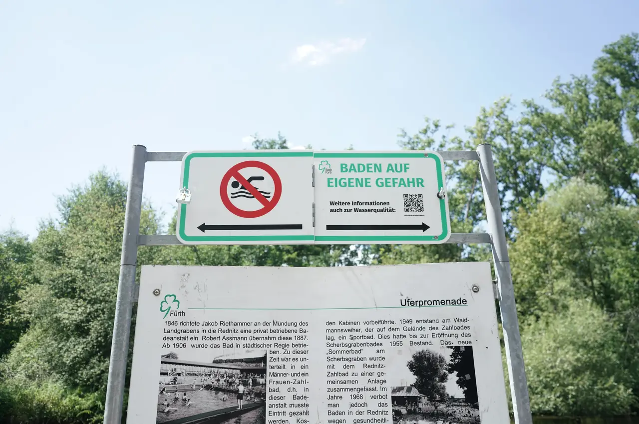 Schild mit der Aufschrift "Baden auf eigene Gefahr" an der Rednitz