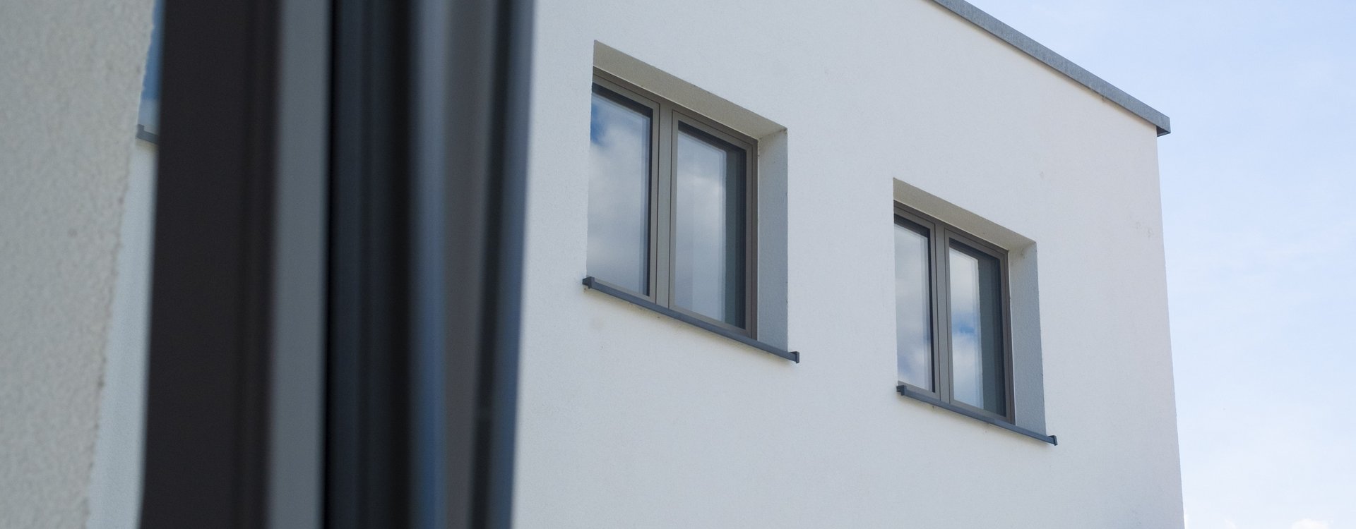 Blick aus dem Fenster auf ein Neubaugebäude mit schallisolierten Fenstern