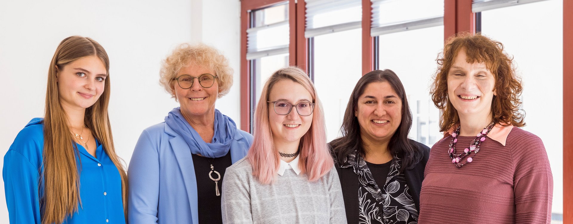 Das Team der fübs vor einer Fensterwand mit der Seniorenbeauftragten (zweite von links) und der Beauftragten für Menschen mit Behinderung (ganz rechts).