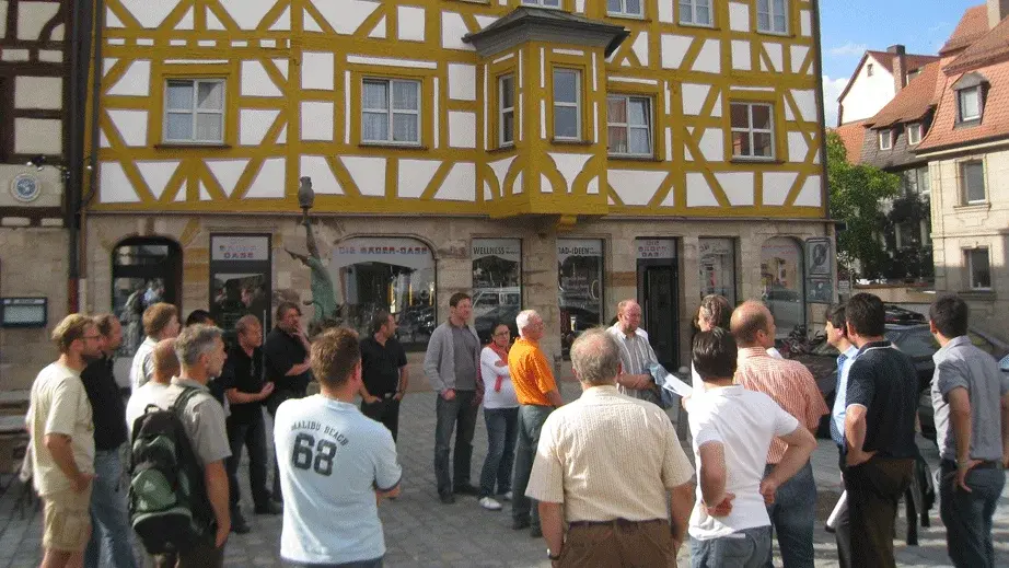 Das Netzwerk Handwerk-Denkmalpflege trifft sich bei einem Vororttermin vor einem Fachwerkhaus in der Fürther Innenstadt.