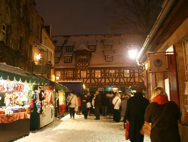 Buden und Menschen bei Schnee auf der Altstadtweihnacht.