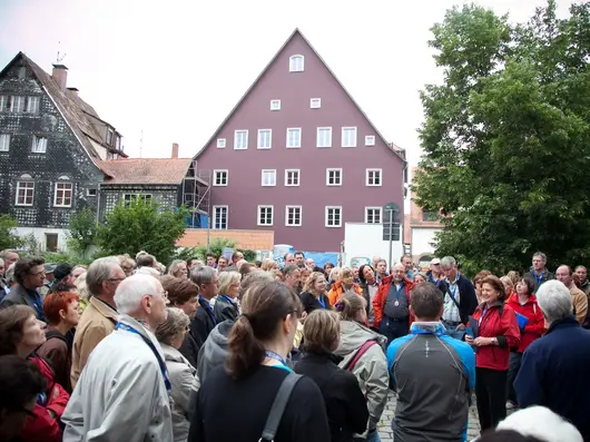 Menschengruppe hört einer Stadtführung zu. 