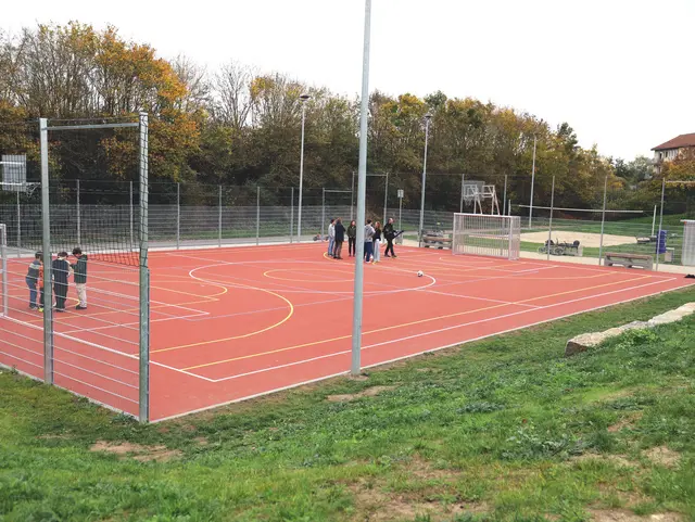 Sportfläche mit Basketballkörben und Toren auf roter Kunststofffläche; Klick öffnet Bild in größerer Darstellung. 