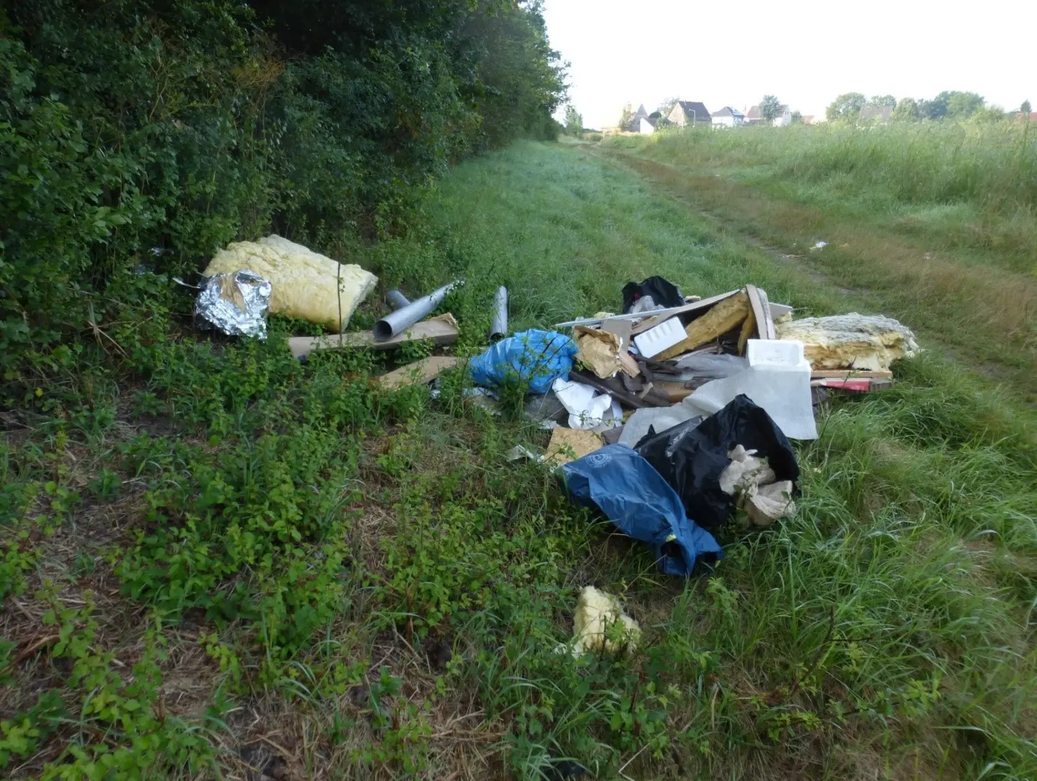 Dämmmaterial und aufgerissene Säcke an einem Waldstück