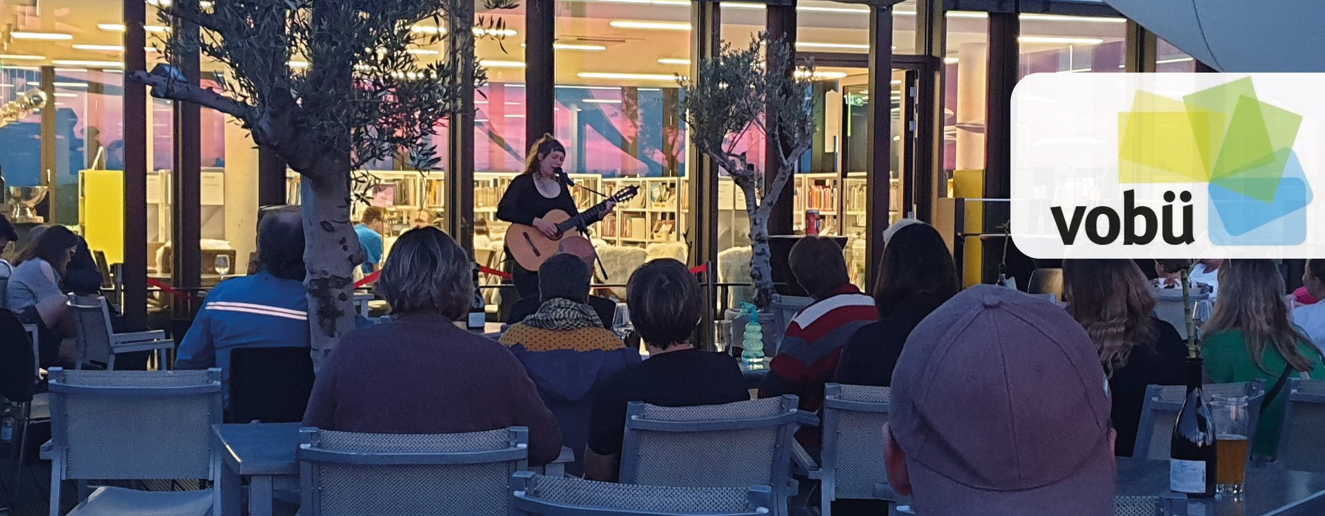 Eine Musikerin mit Gitarre auf der Dachterrasse der Volksbücherei