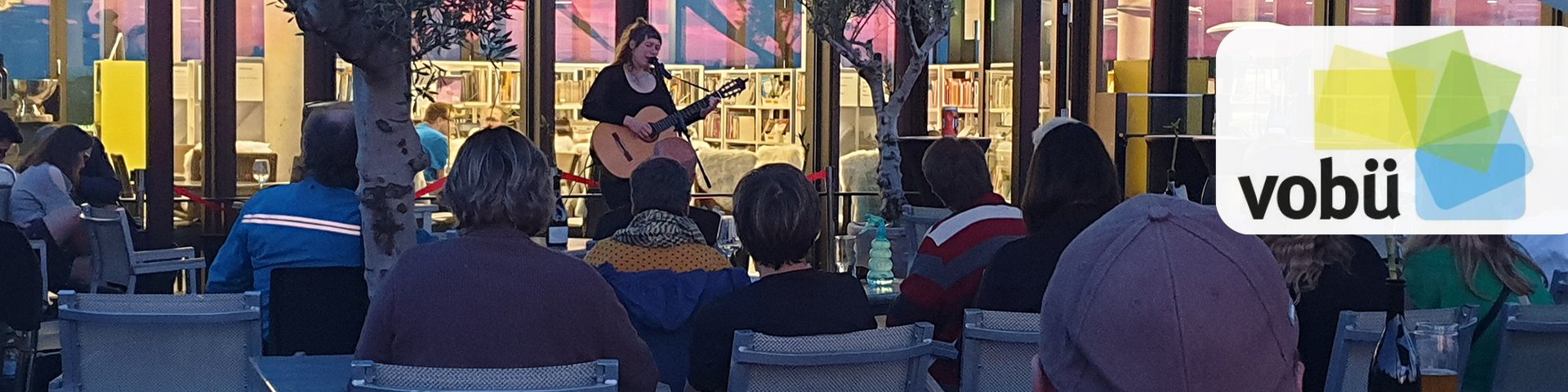 Eine Musikerin mit Gitarre auf der Dachterrasse der Volksbücherei